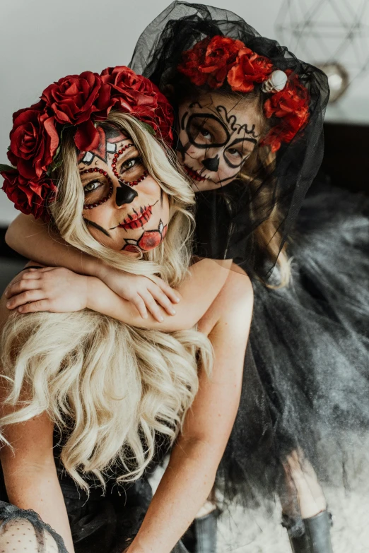 two women dressed up in day of the dead costumes, a portrait, by Julia Pishtar, trending on pexels, laying on roses, square, black and red scheme, kids