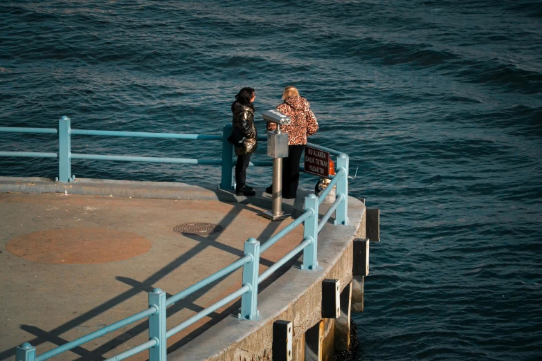 a couple of people standing on top of a pier, birds eye photograph, looking around a corner, 2022 photograph, japan shonan enoshima