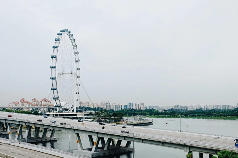 a bridge over a body of water with a ferris wheel in the background, pexels contest winner, hurufiyya, set on singaporean aesthetic, olafur eliasson, long view, sparsely populated