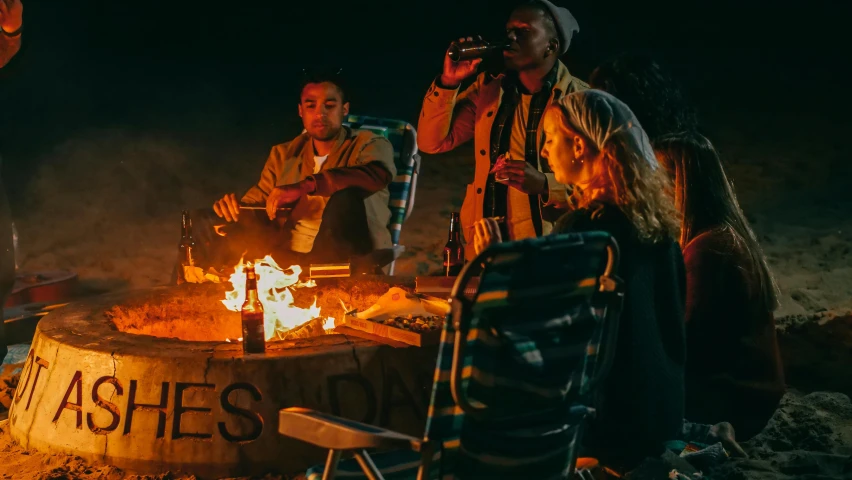 a group of people sitting around a fire pit, pexels contest winner, barrel fires and tents, nightcap, profile image, beach party