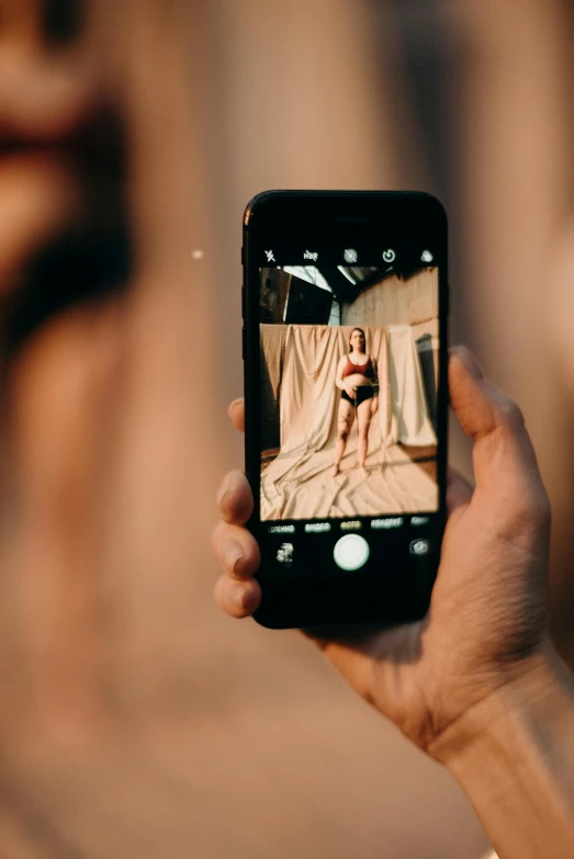 a person taking a picture with a cell phone, a picture, inspired by Elsa Bleda, trending on pexels, body portrait, distorted photo, a wooden, iphone video