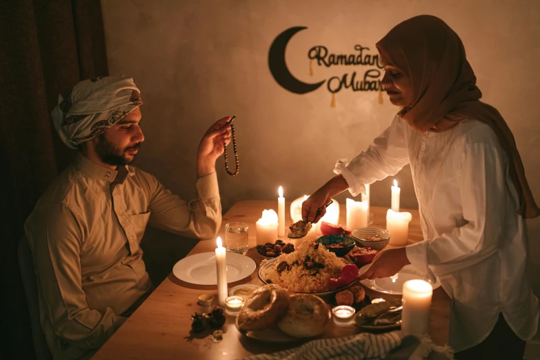 a man and a woman sitting at a table with candles, pexels contest winner, hurufiyya, arab inspired, ready to eat, ☁🌪🌙👩🏾, thumbnail