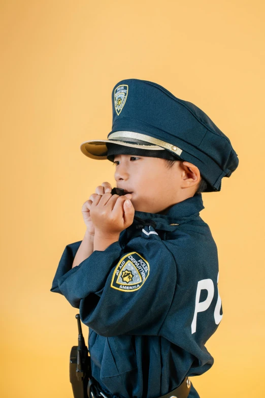 a little boy dressed up as a police officer, a cartoon, trending on pexels, profile image, colored photo, yanjun chengt, thinking pose