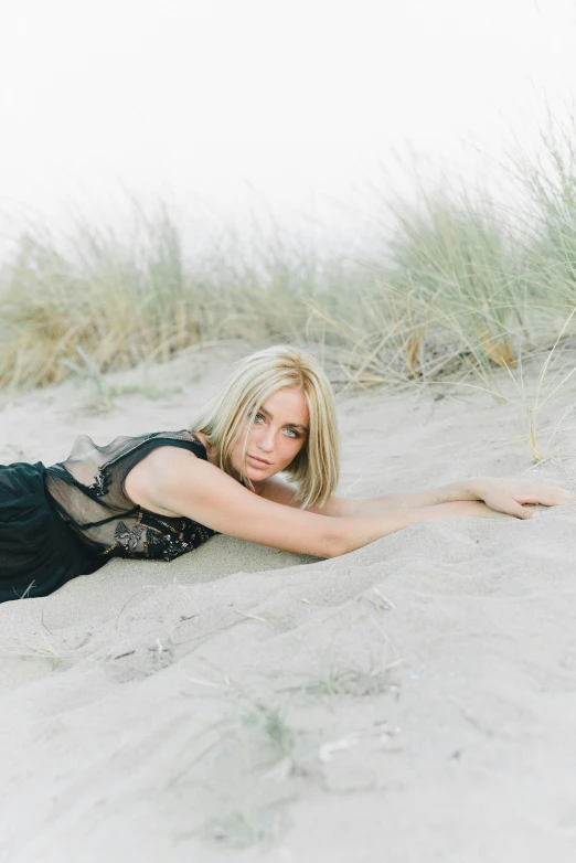 a woman laying in the sand on a beach, by Sara Saftleven, blonde beautiful young woman, with soft bushes, trending photo, medium format