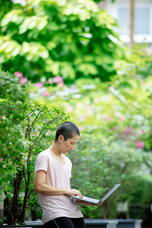 a woman sitting on a bench using a laptop, by Tadashige Ono, happening, lush vegetation, asian male, profile image, at college