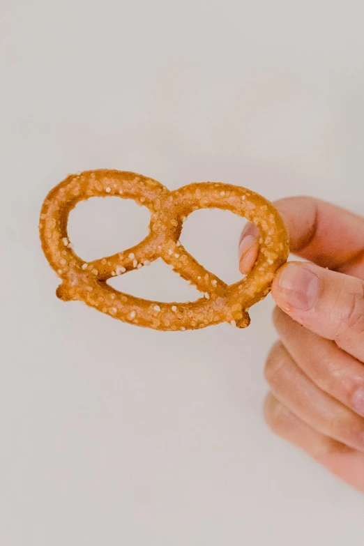 a person holding a pretzel in their hand, profile image, vine twist, no watermark, extra crisp image