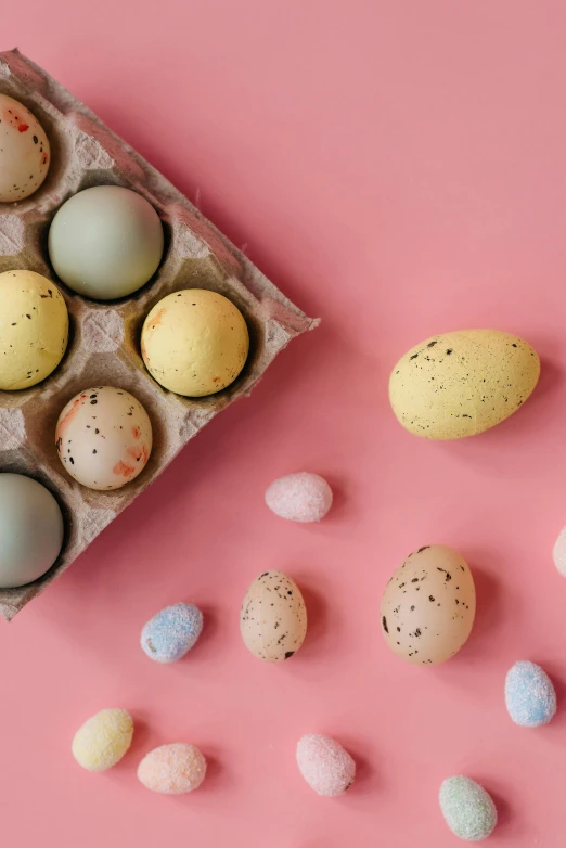 a carton filled with eggs sitting on top of a pink surface, by Ellen Gallagher, trending on pexels, renaissance, candy decorations, speckled, set photo, full product shot