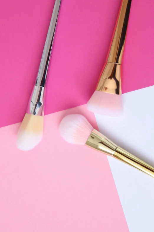 a couple of makeup brushes sitting on top of a pink and white background, gradient white to gold, featured on z brush, demur, soft delicate draconic features