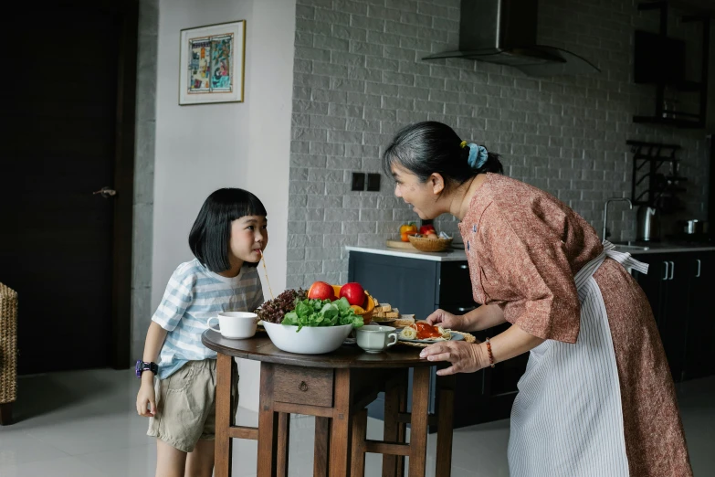 a woman standing next to a little girl at a table, pexels contest winner, ingredients on the table, asian woman, little boy, profile image