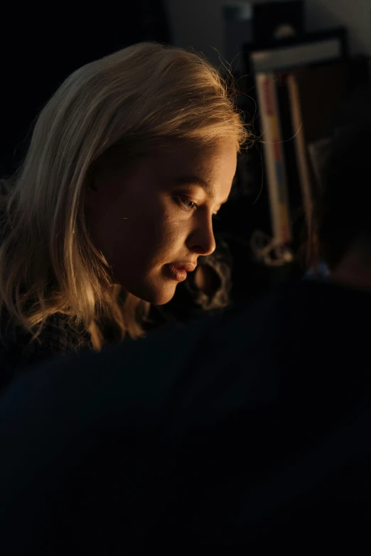 a woman sitting in front of a laptop computer, by David Donaldson, reddit, photorealism, elle fanning at night, close - up profile face, cinematic light. medium shot, emilia clarke