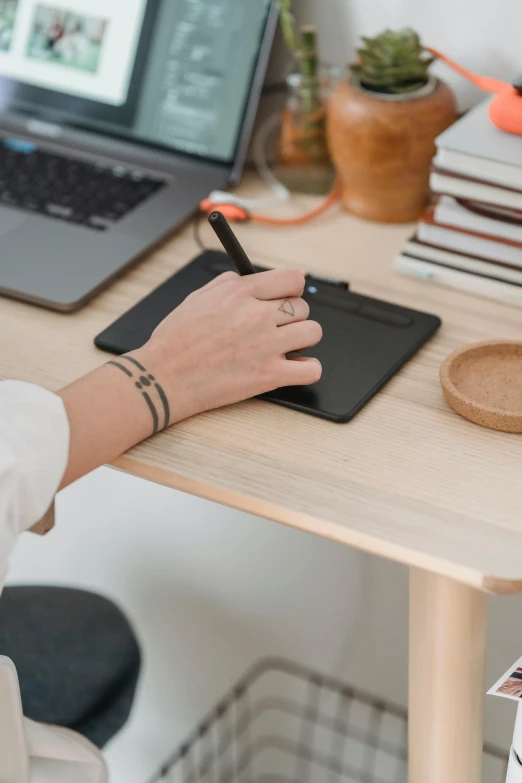 a woman sitting at a desk writing on a notepad, by Robbie Trevino, arbeitsrat für kunst, small gadget, sitting with wrists together, draw with wacom tablet, minimalist home office