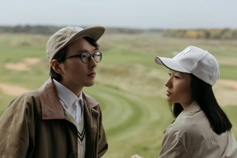 a man and a woman standing next to each other, inspired by Fei Danxu, unsplash, serial art, golf course in background, berets, production still, hunting