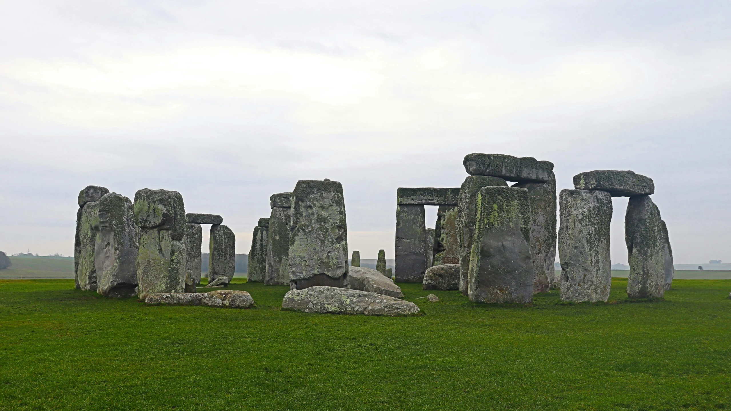 a group of large stones sitting on top of a lush green field, statues, united kingdom, fan favorite, 3/4 front view