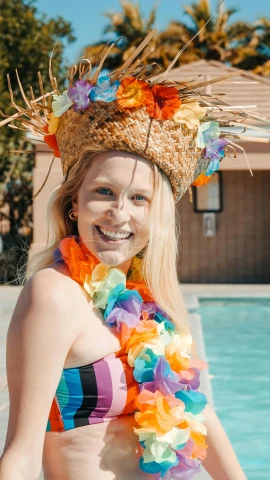a beautiful young woman standing next to a swimming pool, by Robbie Trevino, pexels, wearing a flower headpiece, rainbow clothes, with straw hat, avatar image