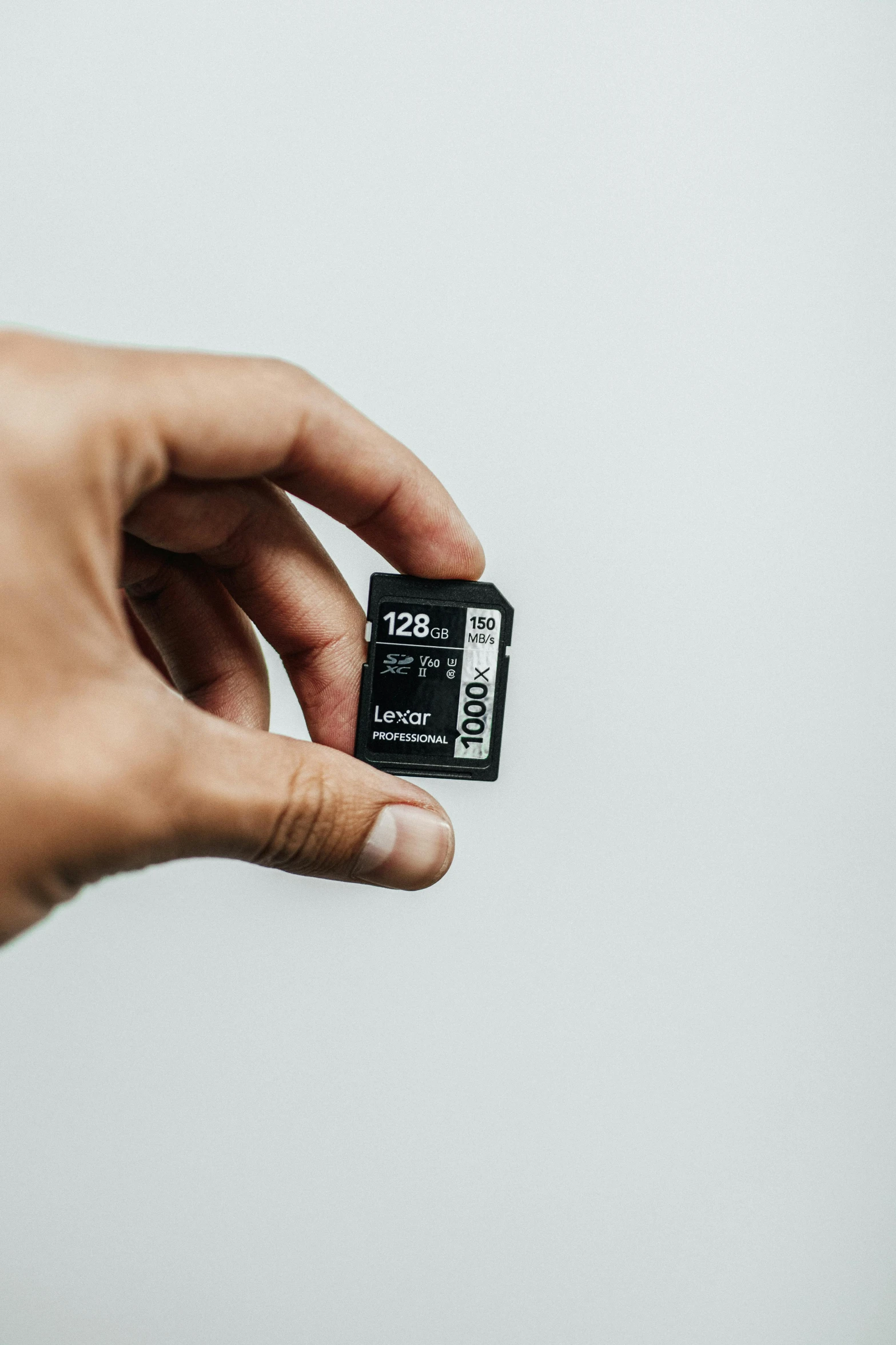 a person holding a micro sd card in their hand, unsplash, black on white background, linus tech tips, 256435456k film, label