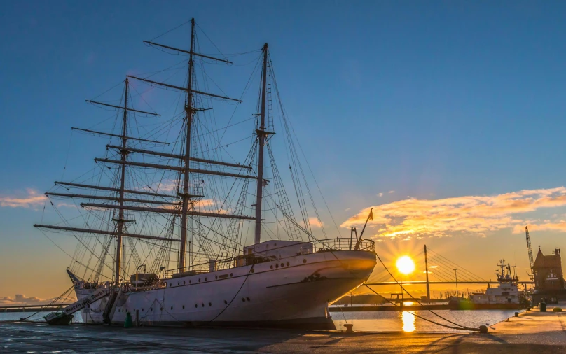 a large white boat sitting on top of a body of water, by Johan Lundbye, pexels contest winner, romanticism, three masts, evening sun, shipyard, posing