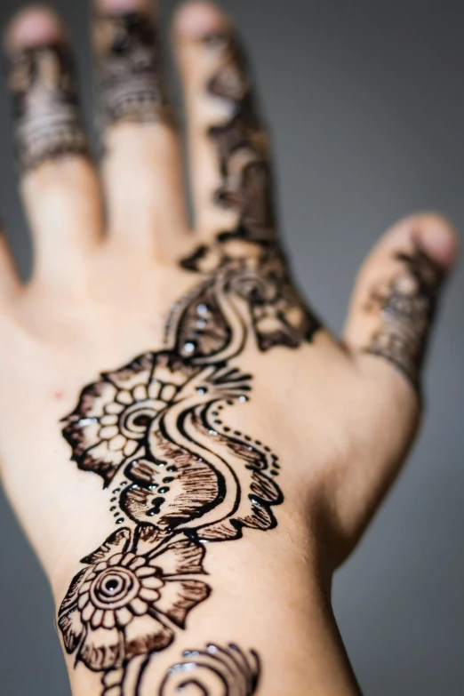 a woman's hand with henna tattoos on it, square, istock, f/5.6, medium-shot