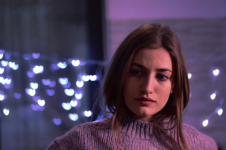 a close up of a person wearing a sweater, a portrait, inspired by Elsa Bleda, trending on pexels, serial art, purple lights, disappointed, movie frame still, phoebe tonkin