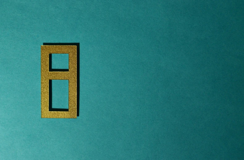 a close up of a window on a blue wall, an album cover, inspired by Josef Albers, pexels contest winner, gold and teal color scheme, eight eight eight, cut out of cardboard, golden number