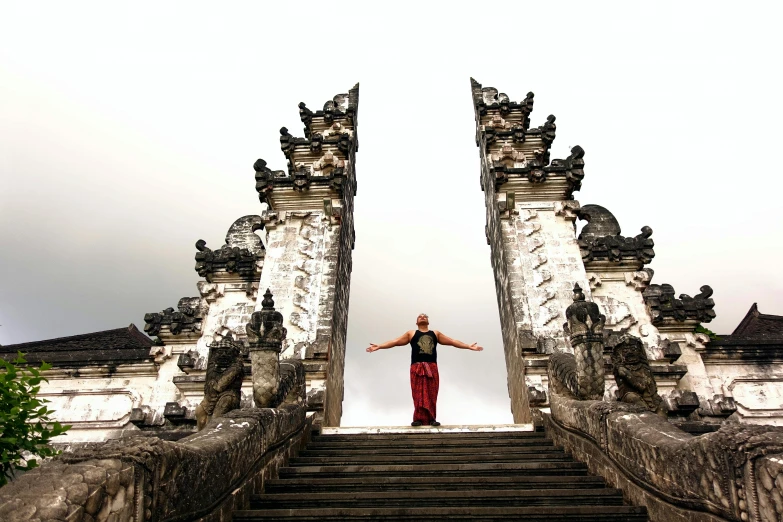 a man standing at the top of a set of stairs, inspired by Steve McCurry, happening, ancient indonesia, huge gate, peak experience ”, standing in front of the altar