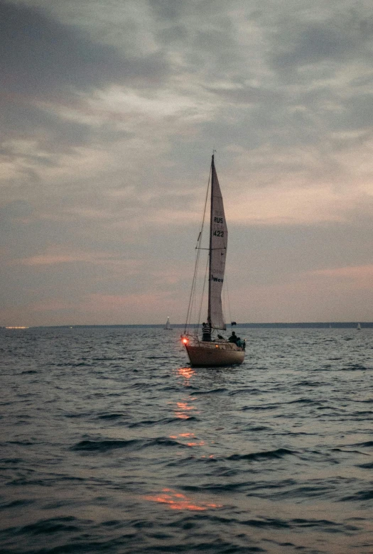 a sailboat in the middle of a body of water, in the evening, on a boat, looking off to the side, the ocean