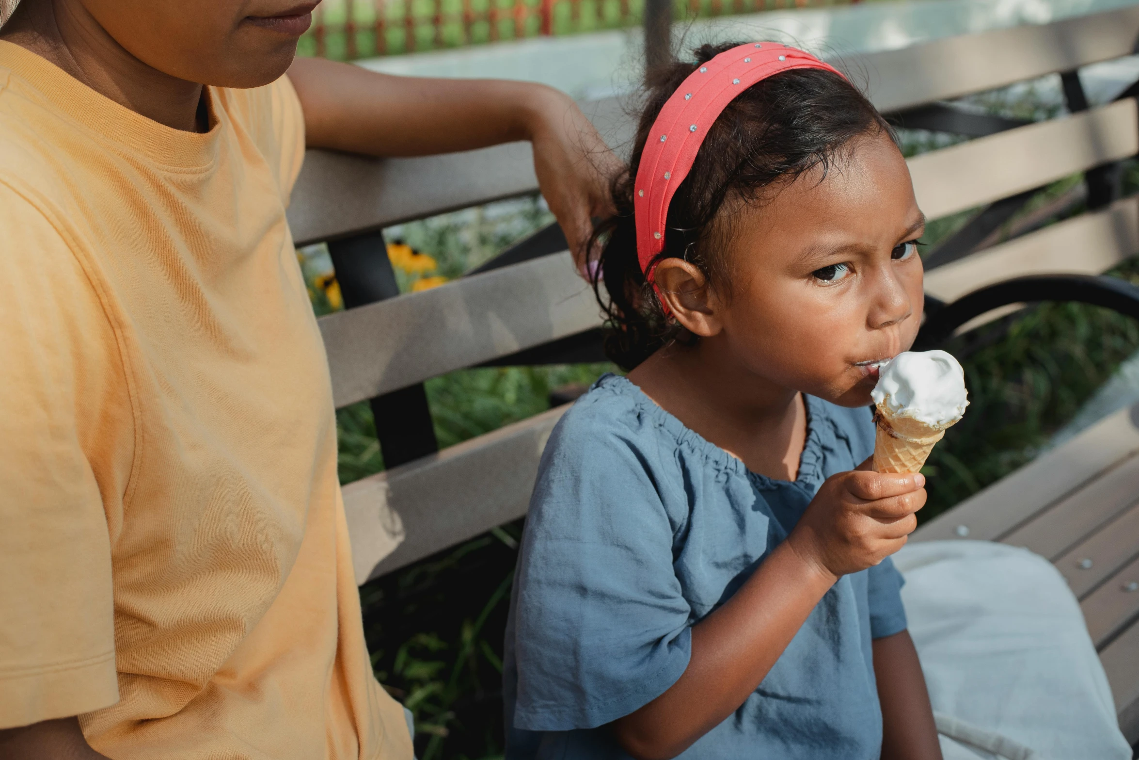 two children sitting on a bench eating ice cream, pexels contest winner, manuka, looking left, thumbnail, cone shaped