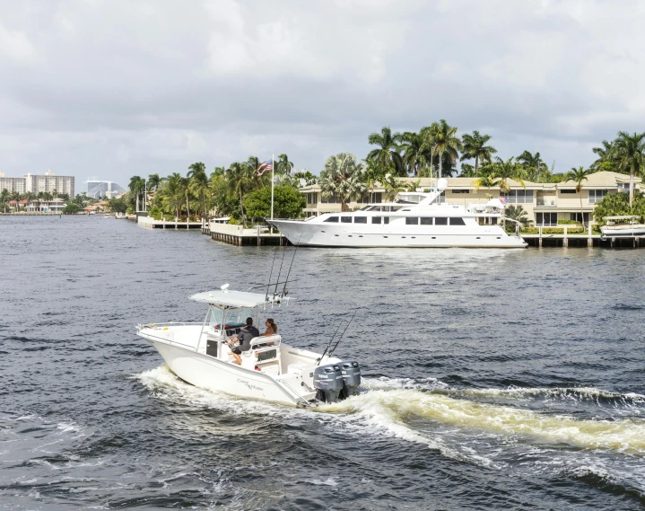 a couple of people riding on the back of a boat, mar-a-lago, fishing boat, 3 boat in river, zoomed out