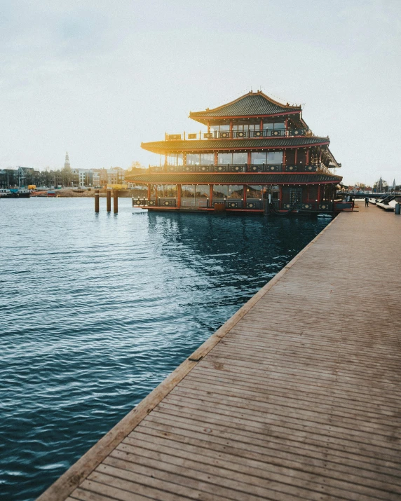 a wooden pier next to a body of water, chinese building, having a good time, harbour, sunfaded