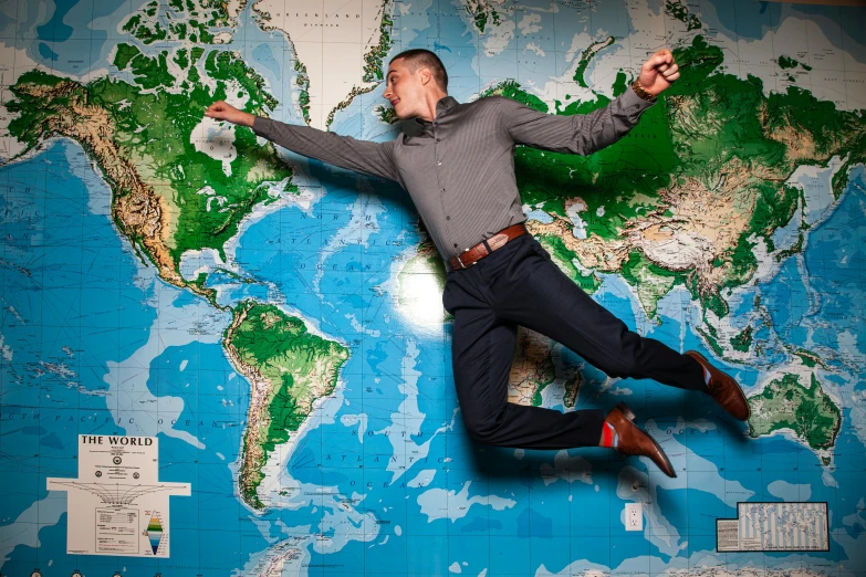 a man jumping in the air in front of a world map, professional portrait photo, 64x64, flat earth, lynn skordal