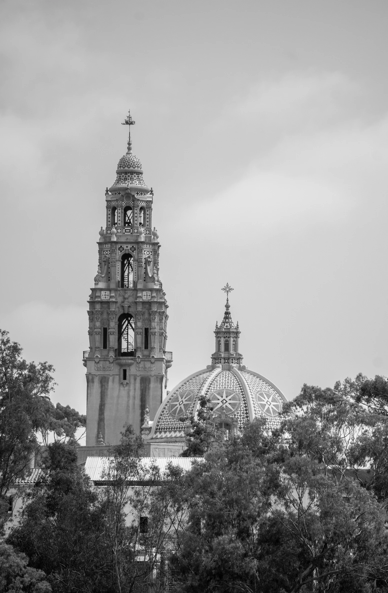 a black and white photo of a clock tower, a black and white photo, by Dave Melvin, baroque, mexican folklore, skyline showing, churches, martin sandiego