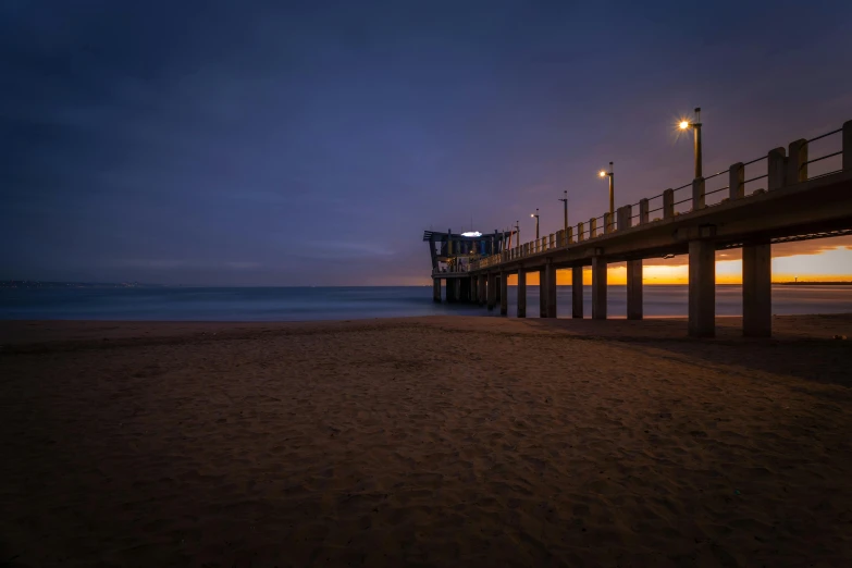 a pier sitting on top of a sandy beach, by Sebastian Spreng, unsplash contest winner, australian tonalism, 8k hdr dusk light, tie-dye, medium format. soft light, nightfall