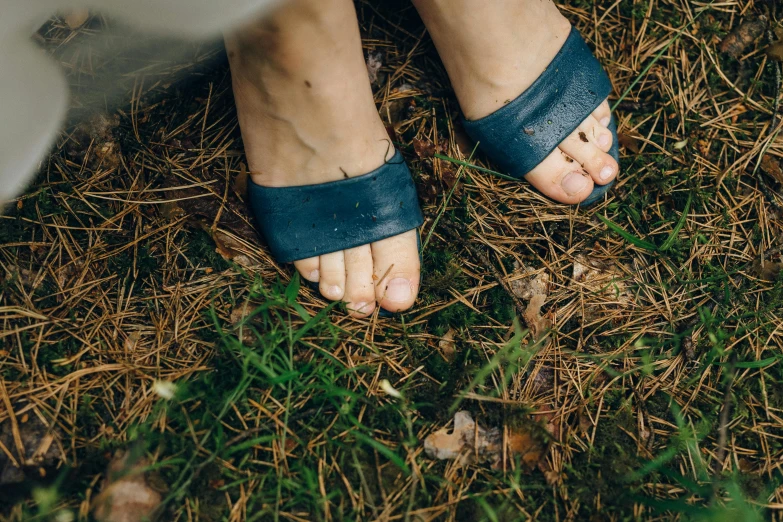 a close up of a person's feet in sandals, pexels, overgrown spamp, blue and grey, sustainable materials, thumbnail