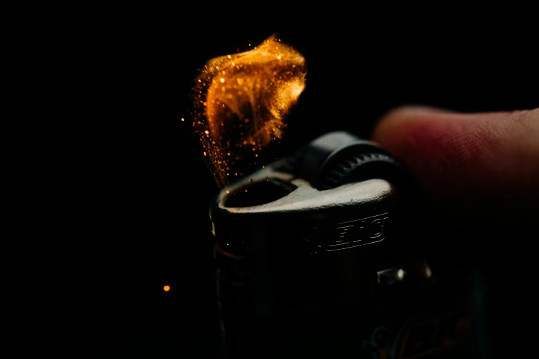 a close up of a person holding a lighter, a macro photograph, by Adam Marczyński, pexels, process art, shiny golden, instagram post, fireball, medium format. soft light