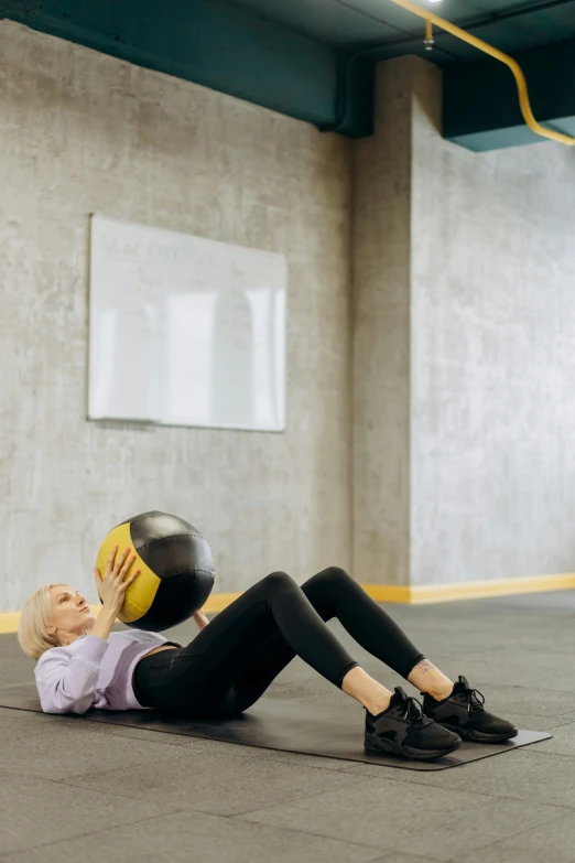 a woman laying on the ground with a medicine ball, pexels contest winner, renaissance, in an office, high textured, dynamic movement, non-binary