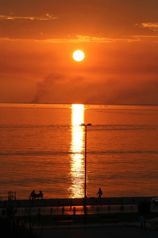 the sun is setting over a body of water, tallinn, ((sunset)), telephoto vacation picture, naples