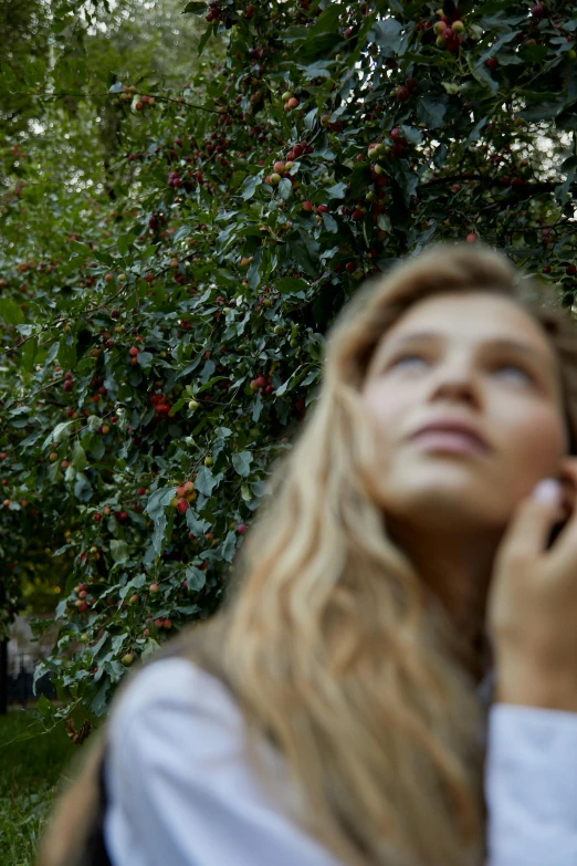 a woman holding a cell phone to her ear, an album cover, trending on unsplash, renaissance, bushes, grace moretz, 15081959 21121991 01012000 4k, under the soft shadow of a tree