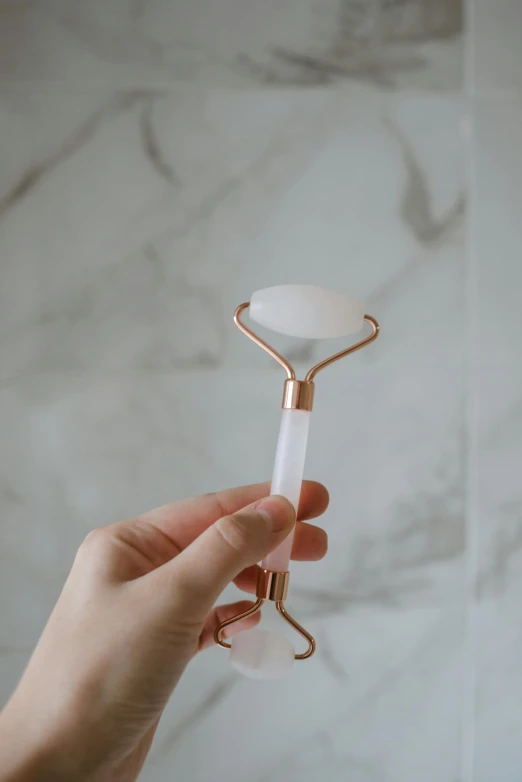 a person holding a marble roller in their hand, by Julia Pishtar, unsplash, clear [bronze] face, speculum, glossy white, copper