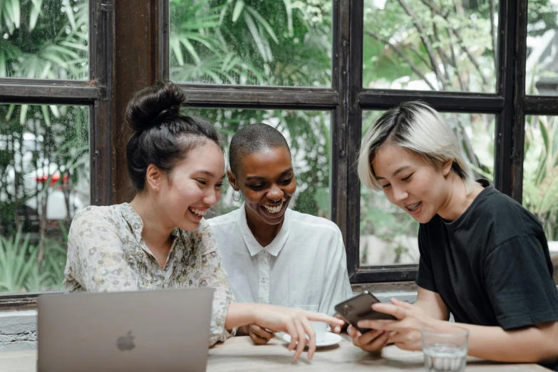 three women sitting at a table looking at a laptop, pexels contest winner, sasai ukon masanao, mobile learning app prototype, embracing, background image