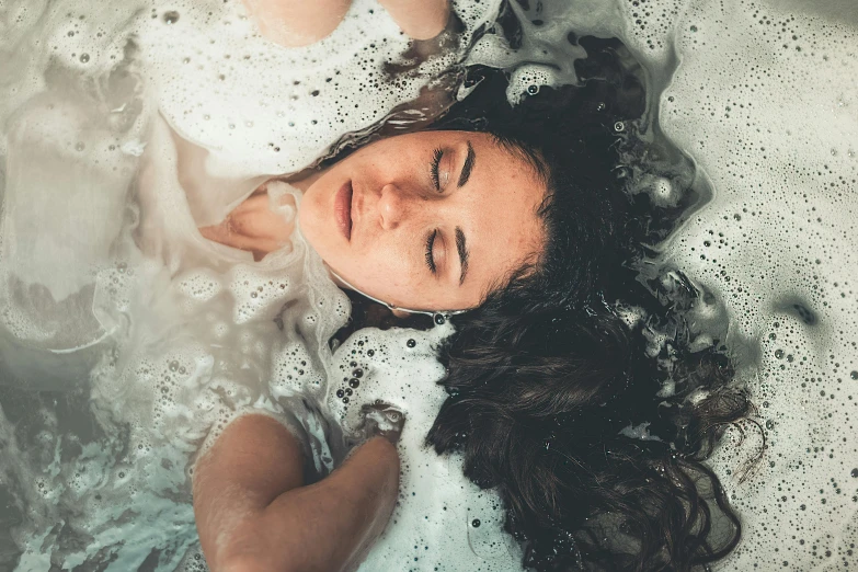 a woman taking a bath in a bathtub, a photo, inspired by Elsa Bleda, trending on pexels, renaissance, hair floating covering chest, float, ilustration, teenage girl