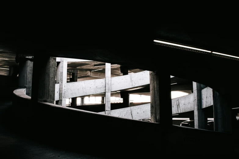 a man riding a skateboard up the side of a ramp, a photo, inspired by Elsa Bleda, unsplash contest winner, brutalism, car garage, ceiling hides in the dark, blame! brutalist architecture, set inside of parking garage