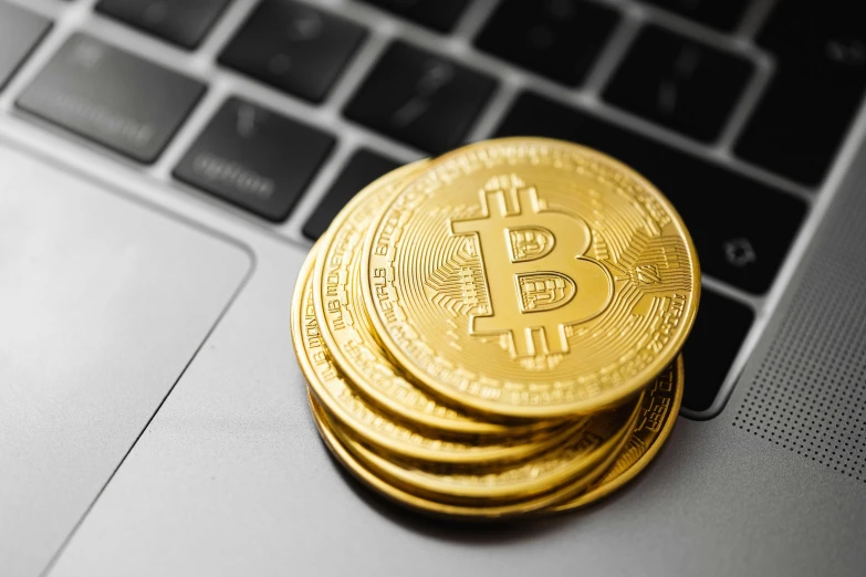 a stack of golden bitcoins sitting on top of a laptop, trending on pexels, 🦩🪐🐞👩🏻🦳, circle, 555400831, chris scalf