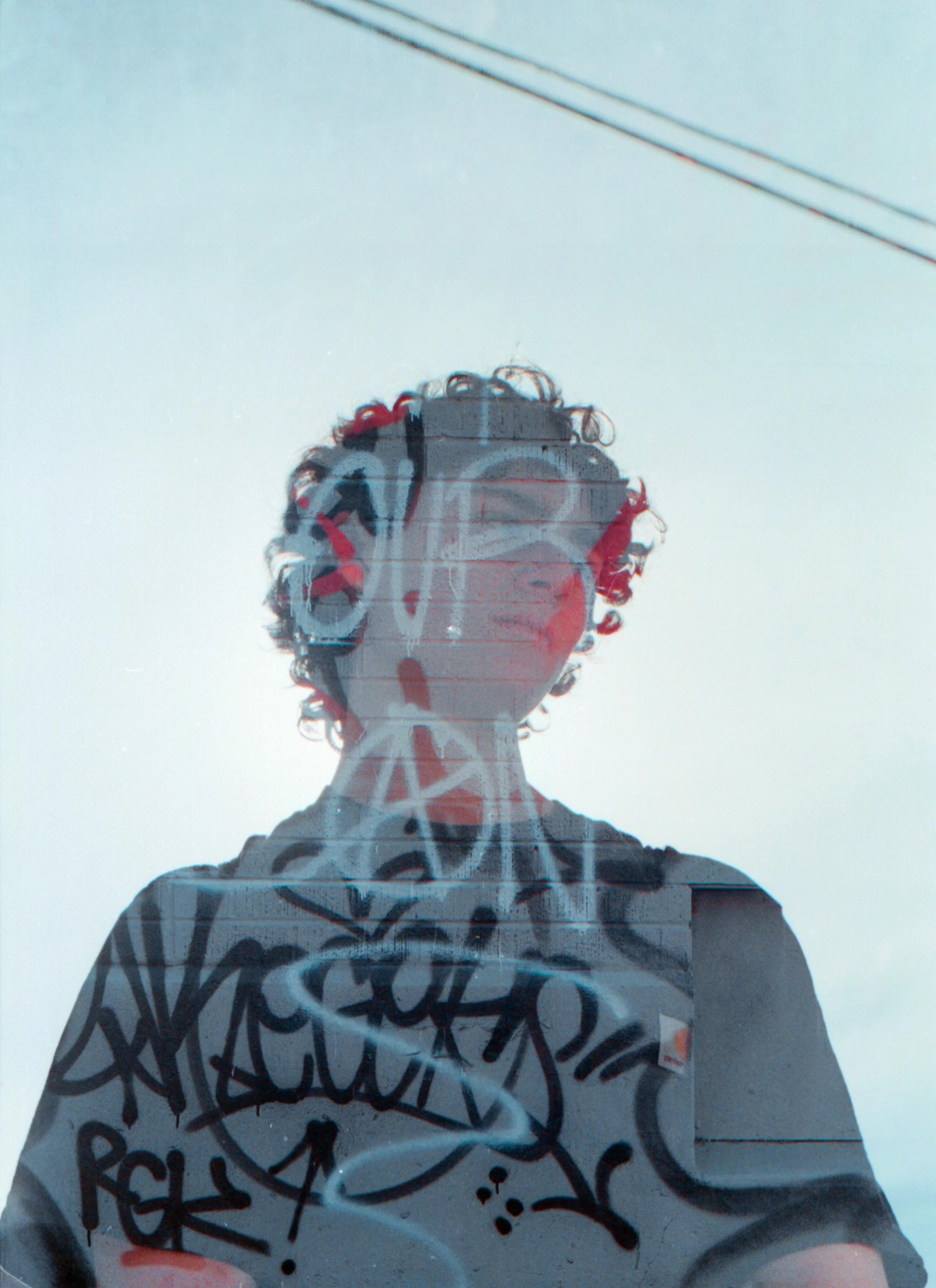 a man standing in front of a mirror covered in graffiti, an album cover, pexels, curly haired, overexposed sunlight, ((portrait)), human face with bright red yes