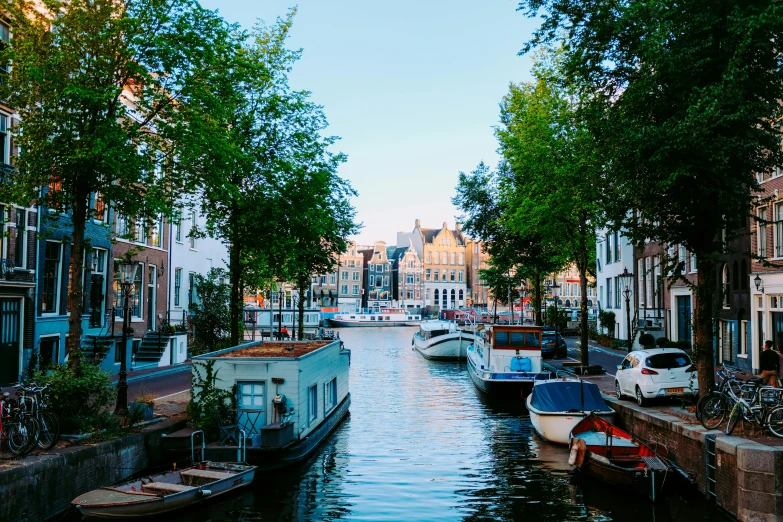 a canal filled with lots of boats next to tall buildings, pexels contest winner, delft, thumbnail, fan favorite, brightly lit