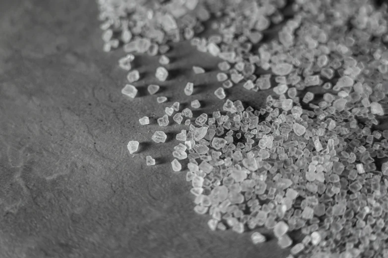 a pile of sugar sitting on top of a table, a macro photograph, by Emma Andijewska, pexels, grainy photorealistic, terrazzo, grey, engraving