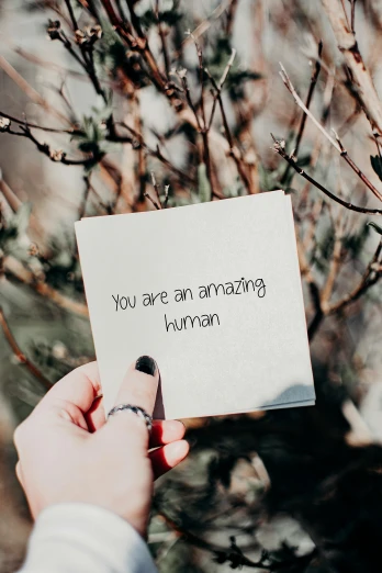 a person holding a piece of paper with writing on it, by Maggie Hamilton, pexels contest winner, romanticism, humanoid, you're something special, better known as amouranth, a still of a happy