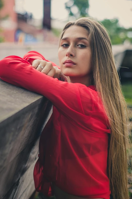a beautiful young woman sitting on top of a wooden bench, a portrait, inspired by Elsa Bleda, pexels contest winner, renaissance, long hair and red shirt, woman in streetwear, close up portrait photo, wearing a track suit