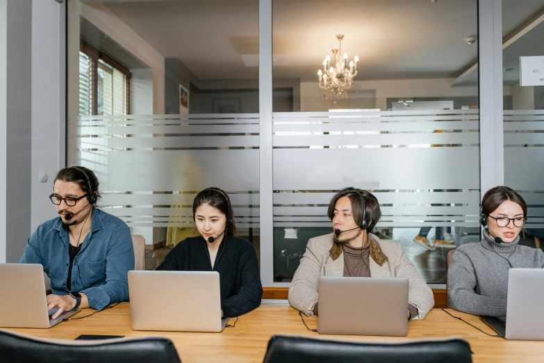 a group of people sitting at a table with laptops, by Jang Seung-eop, trending on unsplash, in an call centre office, avatar image, ethnicity : japanese, studio photo