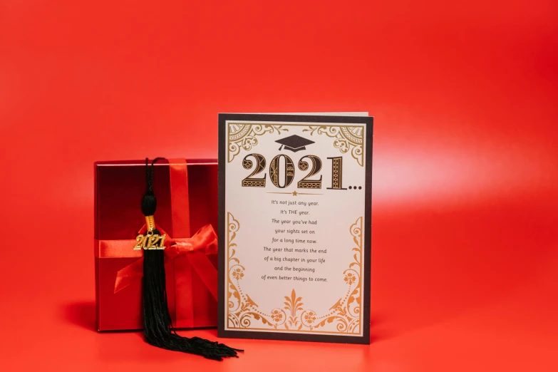 a graduation card sitting on top of a red box, trending on pexels, art nouveau, - 12p, 2021, (1 as december, poster