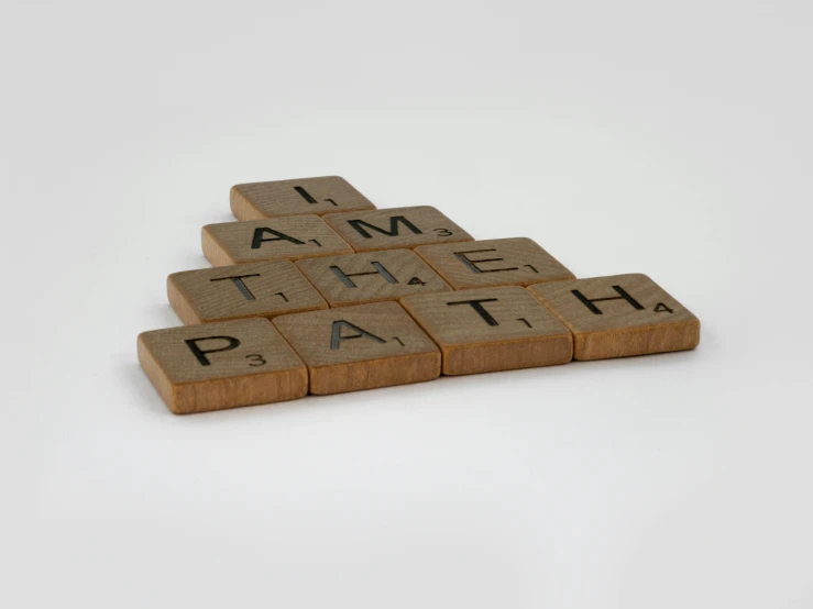 scrabbles spelling i am the path on a white background, inspired by Ian Hamilton Finlay, made of woods, - 12p, 35 mm product photo”, beige