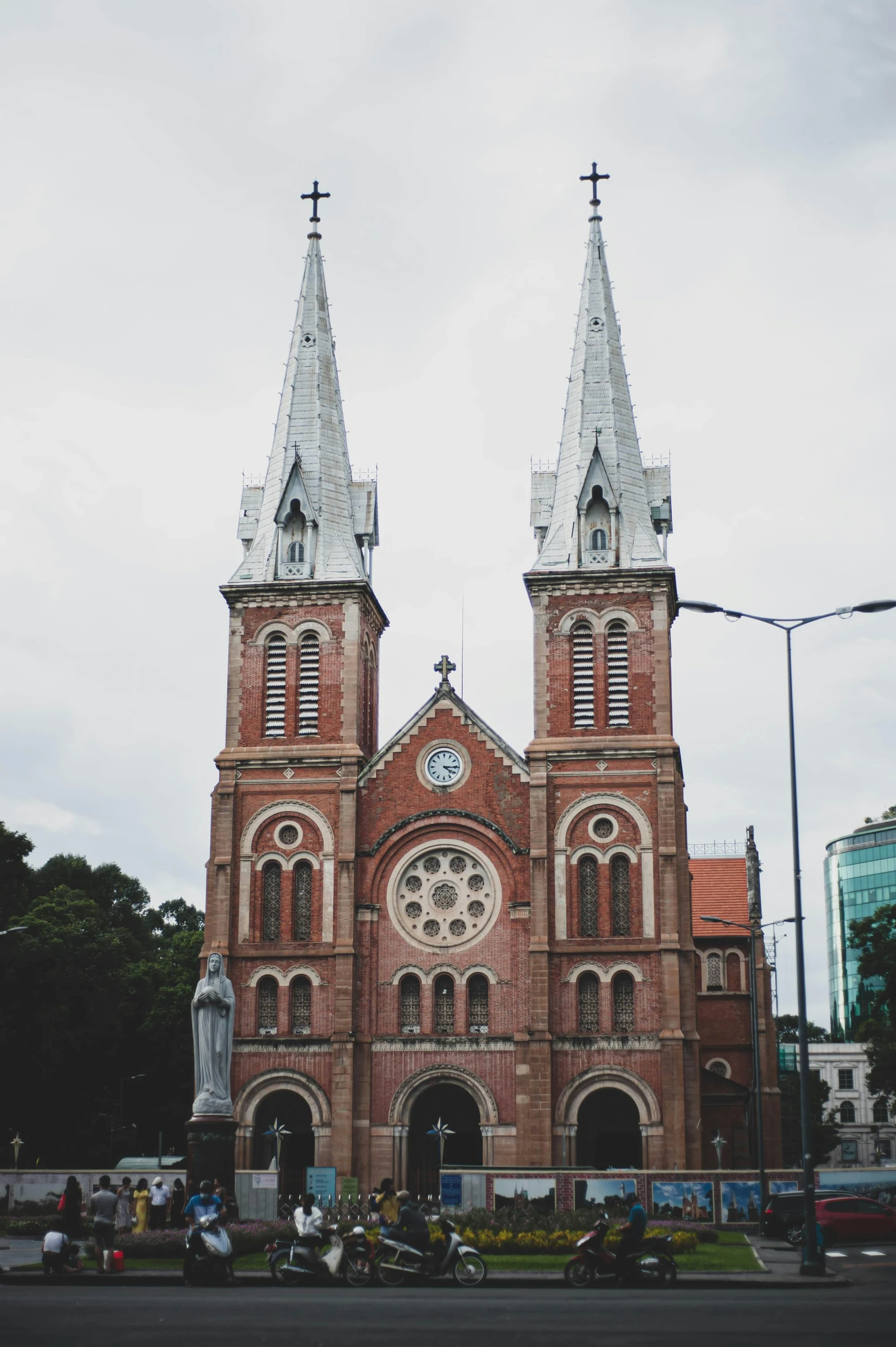 a church with two steeples and a clock on the front, an album cover, inspired by Ruth Jên, trending on unsplash, vietnam, exterior view, high-rise buildings, square